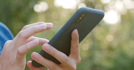 Woman use of mobile phone in city with sunset