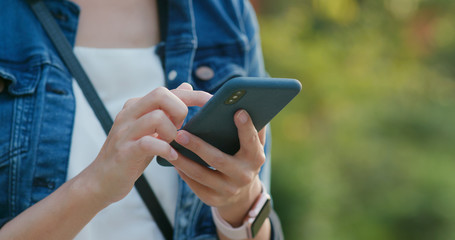 Woman use of mobile phone under sunset