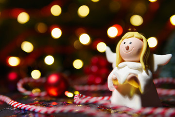 Small toy angel in lights of garland