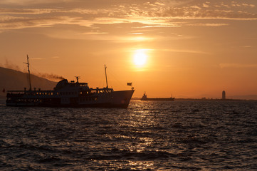 Ship at sea on a background of sunset sky