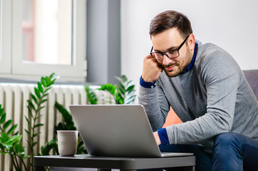 Handsome young man in front of laptop at home