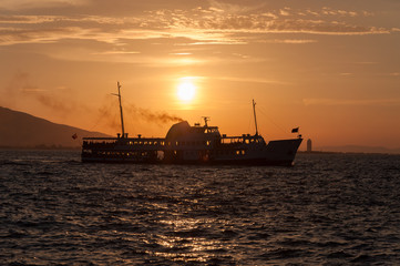 Ship at sea on a background of sunset sky.