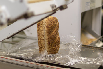 Fresh bread being packaged - 230875038