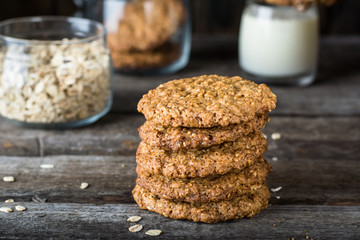 Homemade oatmeal cookies on wooden board on old table background. Healthy Food Snack Concept. Copy space. Milk and cookies. Still life of food. Vegetarian food. Healthy food. Breakfast concept.