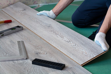 man installs new laminate flooring