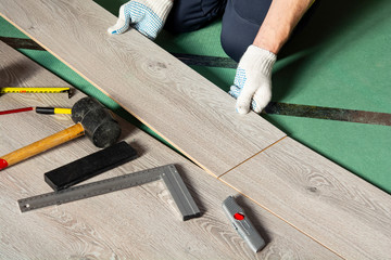 man installs new laminate flooring