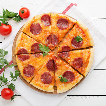 Pepperoni Pizza, Tomatoes And Parsley. Tasty Pepperoni Pizza On White Wooden Background. Overhead View Of Italian Pizza.
