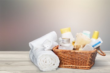 Fototapeta na wymiar Bath towels and basket with accessories for spa on blur