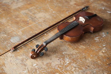 Violin and bow in vintage style on wood background