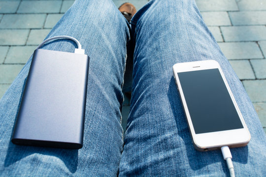 The Man Charges The Phone Using Power Bank