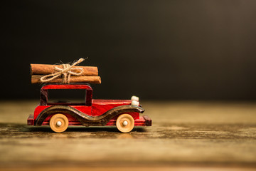 Christmas card with toy car and cinnamon on black