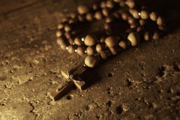 A wooden rosary on an old wooden background