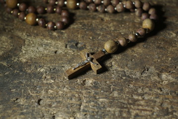 A wooden rosary on an old wooden background