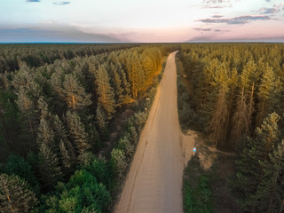 Gravel road in the Russian forest at sunset
