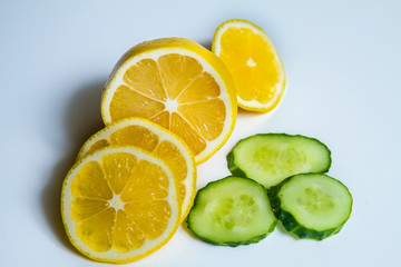ripe cucumber and lemon on white background