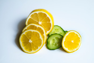 ripe cucumber and lemon on white background
