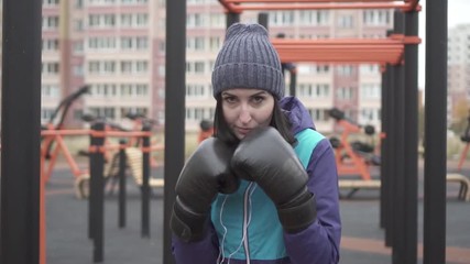 Portrait of a boxer woman in boxing gloves on the street,slow mo