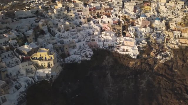 Panning aerial, coastal town of Oia