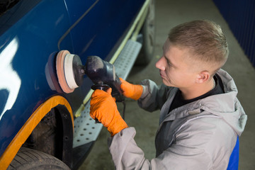 Repair and painting car car mechanic. Auto mechanic worker painting car in a paint chamber during...