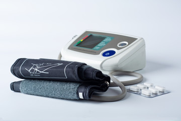 electronic tonometer on a white background with pills