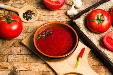 Tomatoes and tomato paste on a rustic wooden table