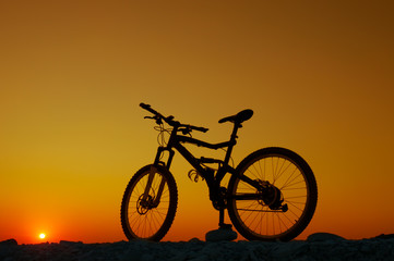 Silhouette of mountain bicycle at sunset background
