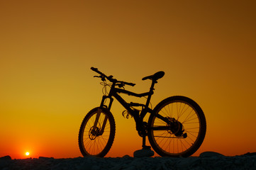 Fototapeta premium Silhouette of mountain bicycle at sunset background