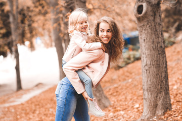 Fototapeta premium Happy mother holding baby girl in park. Motherhood. Maternity. 20s.