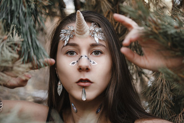 Female unicorn. Fairy girl unicorn walking on the snow in the forest. © Air_Lady