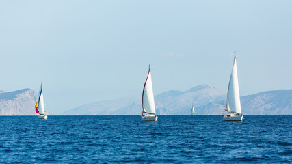 Fototapeta na wymiar Sailing luxury boats participate in yacht regatta in the Aegean Sea in Greece.