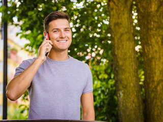 Obraz premium Young man talking on smartphone outdoor