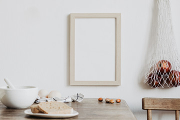 Vintage kitchen interior with mock up photo frame, straw basket, natural bread and bag with apples....
