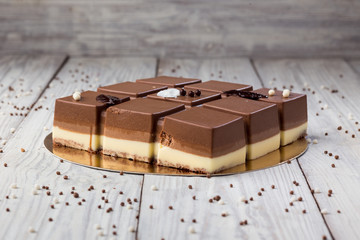 Dark chocolate vegan cake with candies on wooden background