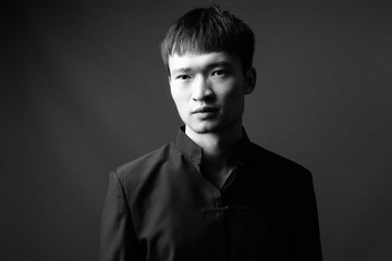 Studio shot of young Chinese man in black and white
