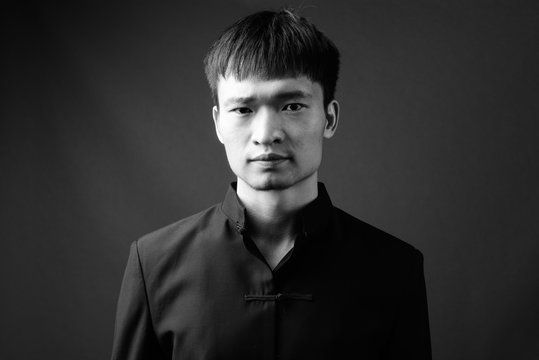 Studio shot of young Chinese man in black and white