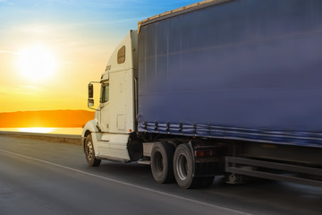 Big truck semi trailer moves on the highway