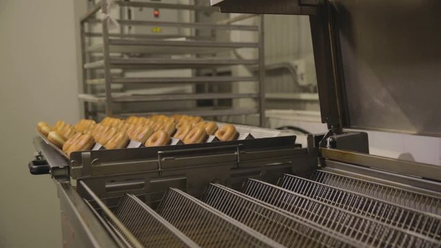 Industrial production of donuts. Scene. The bakery bread industry, candy factory, cookies and bagels or donuts do a lot at the bakery dessert factory