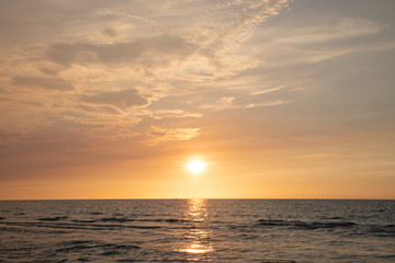Naklejka na ściany i meble sandy beach by the ocean at sunset