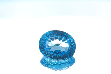 Circular gem of blue topaz on a glass