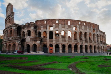 Fototapeta na wymiar ruins of antique Colosseum with green grass lawn in sunise lights, Rome Italy