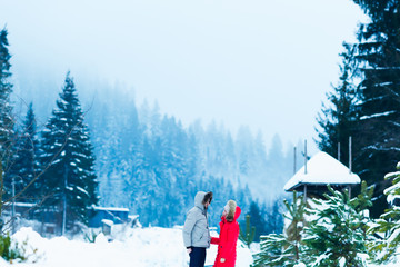 guy and girl in warm clothes with hoods on their heads standing