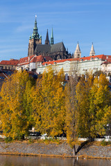 Colorful autumn Prague gothic Castle with the Lesser Town above River Vltava in the sunny Day,...