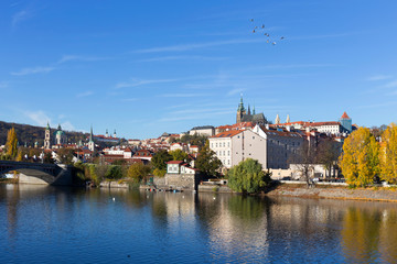Fototapeta na wymiar Colorful autumn Prague gothic Castle with the Lesser Town above River Vltava in the sunny Day, Czech Republic