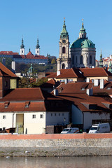 Colorful autumn Prague St. Nicholas' Cathedral with the Lesser Town above River Vltava in the sunny...
