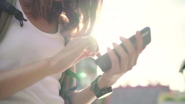 Cheerful Asian backpacker blogger woman using smartphone for direction and looking on location map while traveling at Chinatown in Beijing, China. Lifestyle backpack tourist travel holiday concept.