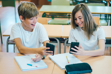 Fototapeta premium Couple young students with smartphone at school
