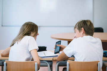 Obraz premium Couple young students with smartphone at school