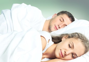 Fototapeta na wymiar Young couple sleeping on the bed in bedroom