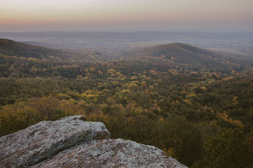 View on a hill in a valley at autumn sunset
