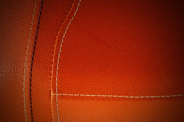 Orange leather with white stitch closeup for background.Part of leather motorcycle seat.